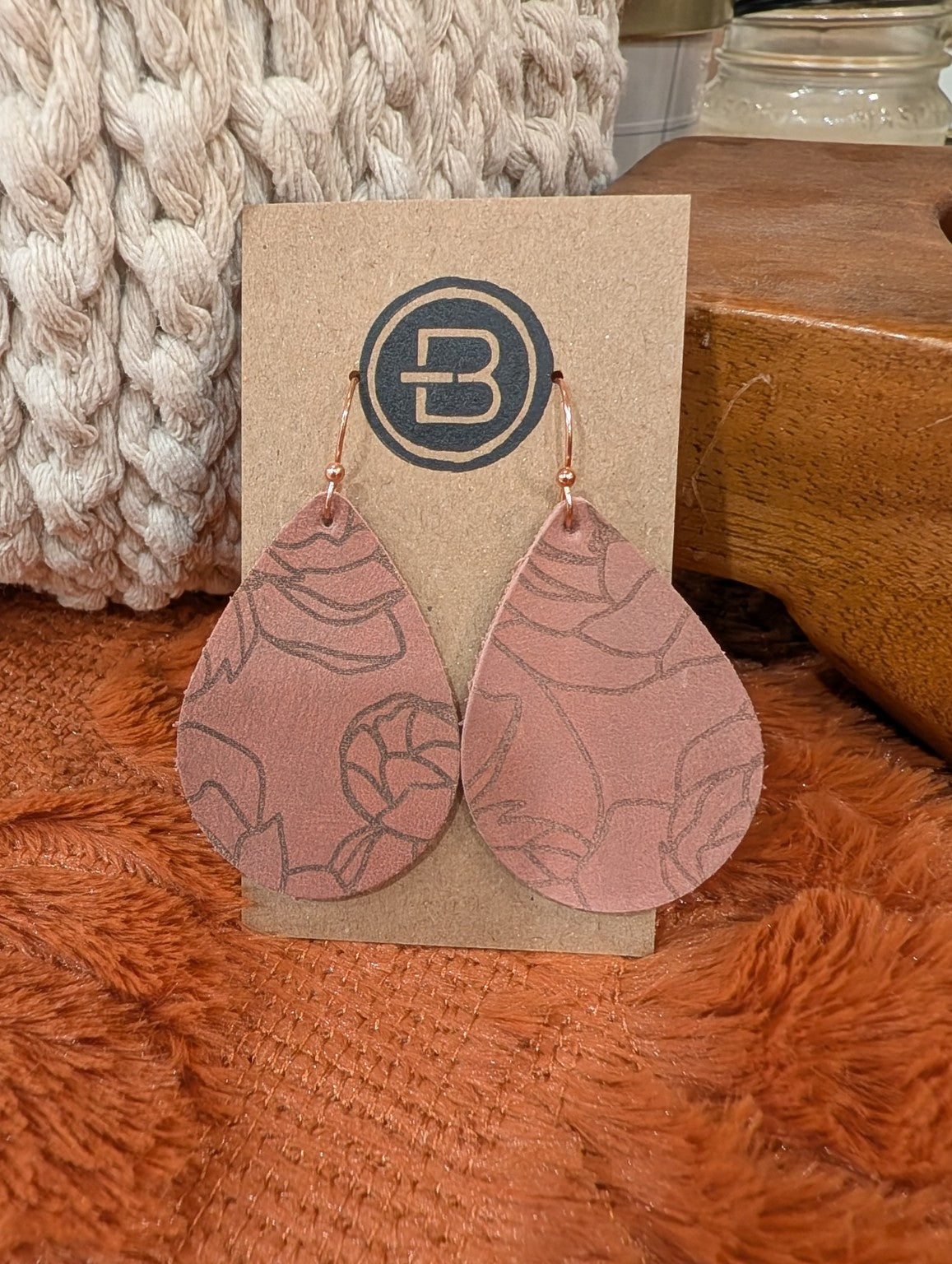 Dusty rose leather teardrop earrings with outlined floral pattern